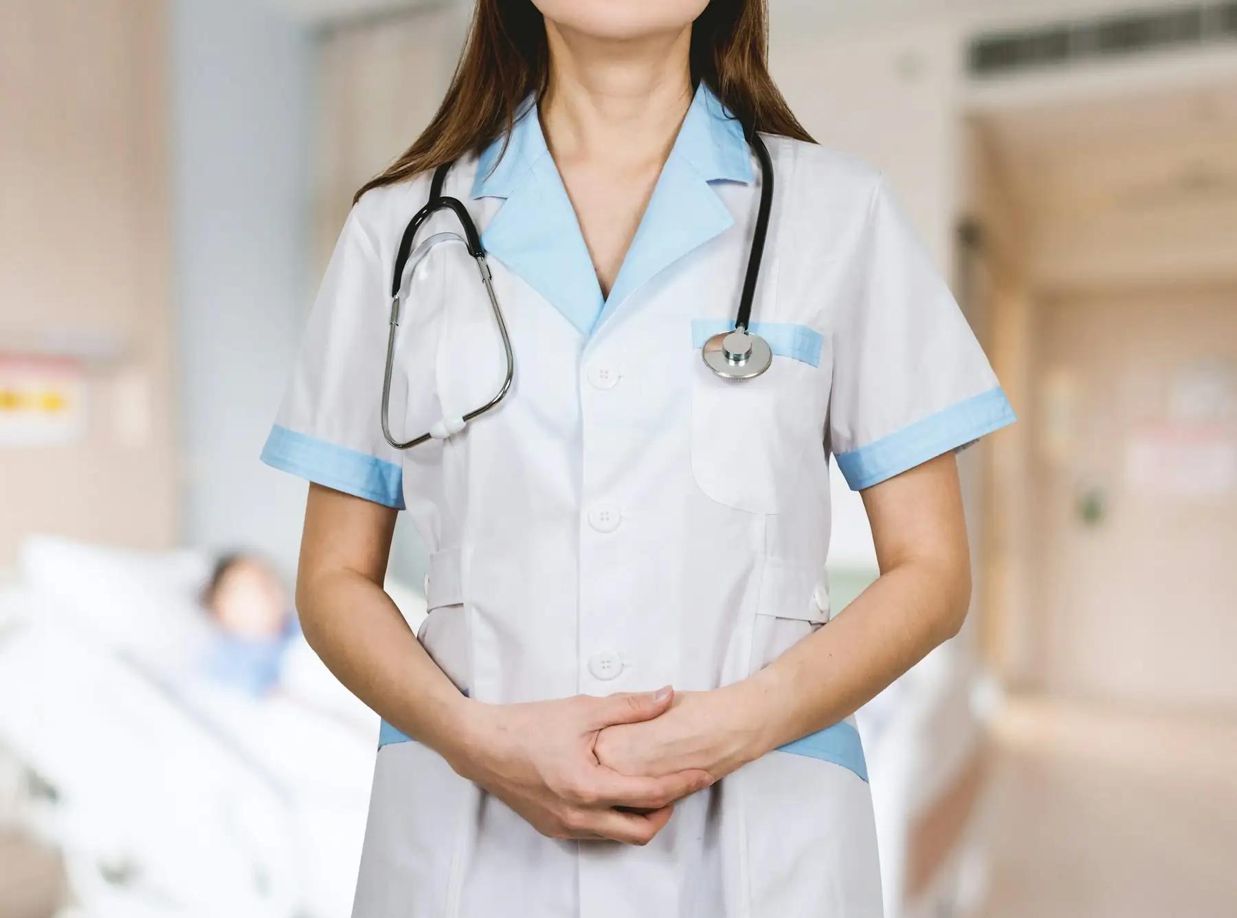 A nurse in uniform standing in a hospital ward